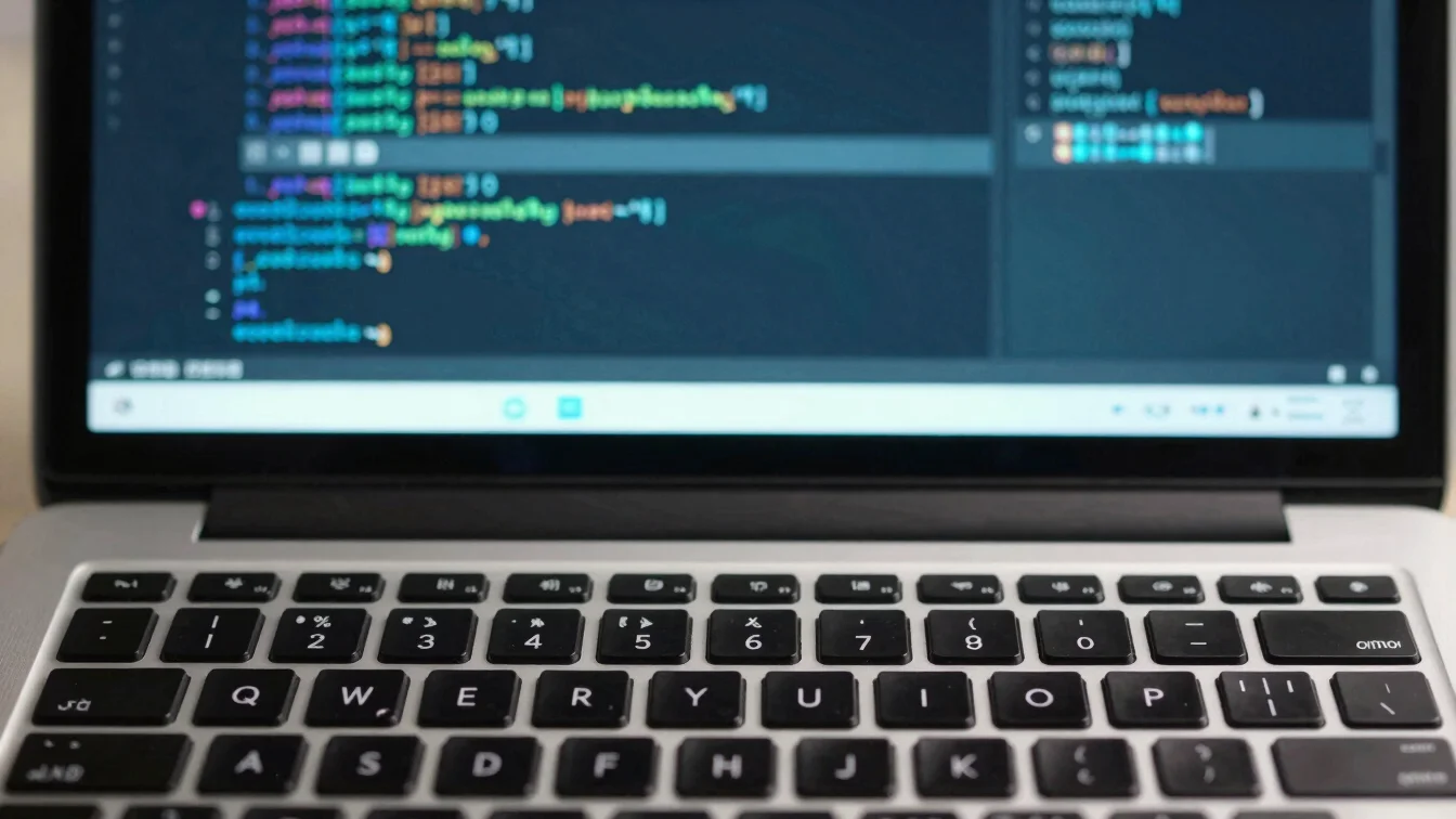 Clean detail crop of a laptop keyboard and a code editor showing configuration files, blue and teal accents, restrained